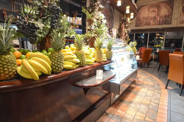 Milton dessert showcase with custom dark woodwork and distinctive Symposium Cafe restaurant interior design.