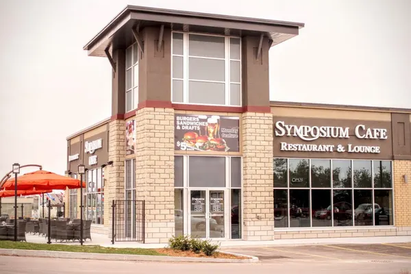 Symposium Cafe Restaurant Lindsay exterior with a welcoming entrance and seasonal patio dining.