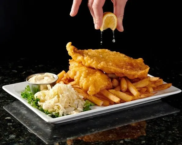 Bolton dinner spot serving golden fish and chips with fries, creamy coleslaw, tartar sauce and fresh lemon.