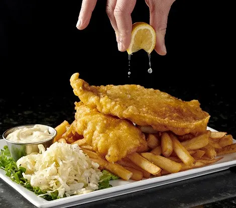 Brantford dinner spot serving golden fish and chips with fries, creamy coleslaw, tartar sauce and lemon.