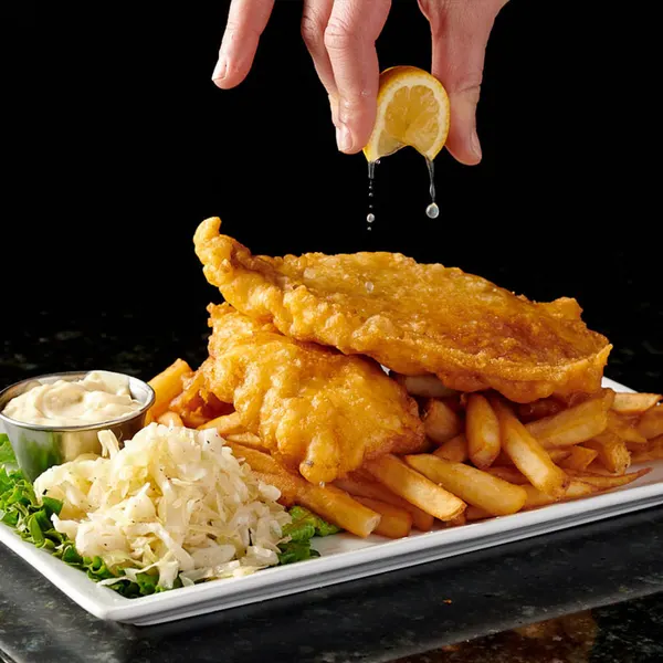 Markham dinner spot serving golden fish and chips with fries, creamy coleslaw, tartar sauce and fresh lemon.