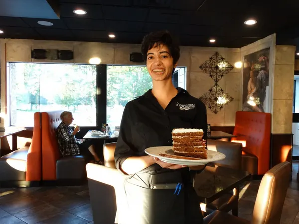 Signature Sky-High Carrot Cake with creamy frosting from the Symposium Cafe gourmet dessert menu.