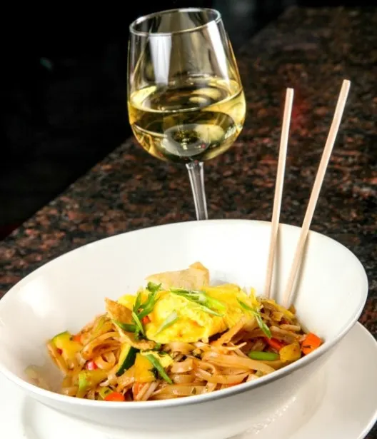 Pad Thai pasta dinner with vegetables and wine at Symposium Cafe Restaurant Oakville