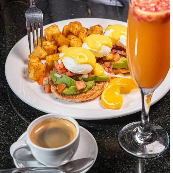 Popular breakfast spot in Bolton Ontario serving avocado eggs benedict with home fries, specialty coffee and mimosa at Symposium Cafe