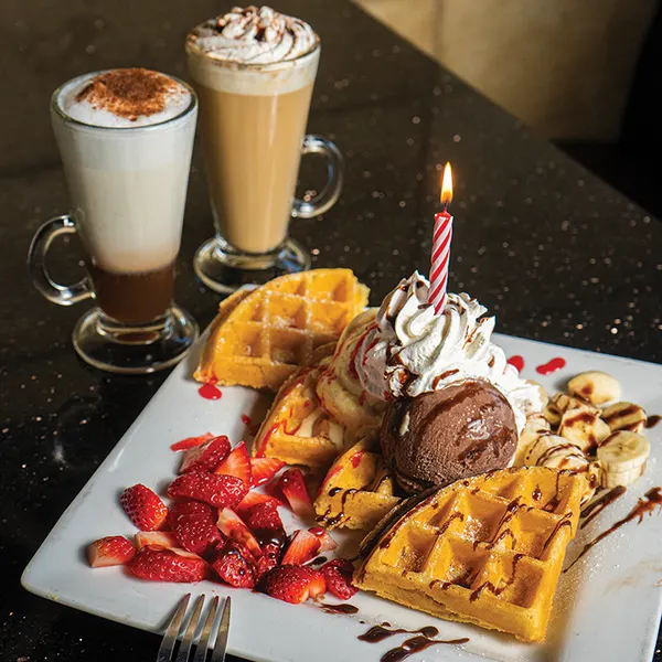 Popular dessert place in Bolton Ontario serving Belgian waffles with ice cream, whipped cream, strawberries and specialty coffee at Symposium Cafe