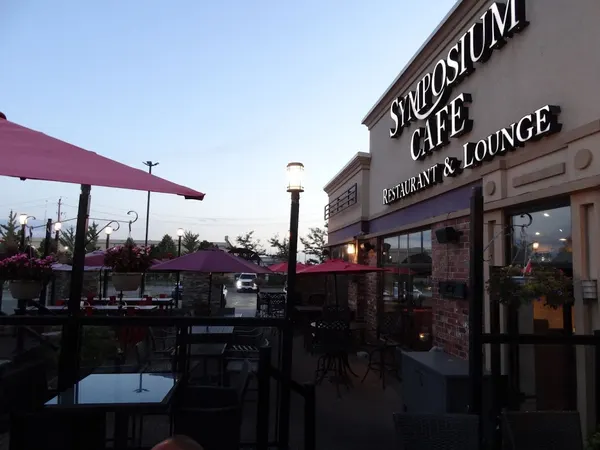 Outdoor patio dining at Symposium Cafe Restaurant in Bolton Ontario with relaxed seating and evening ambiance