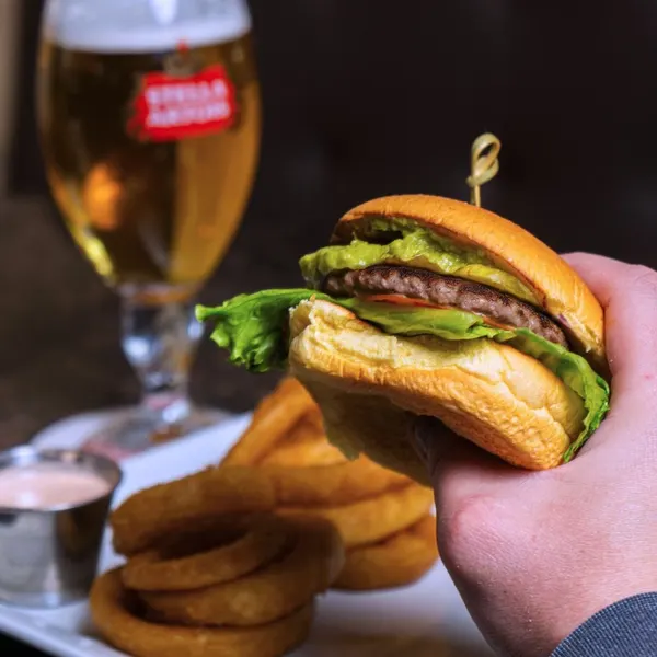 Burger restaurant in Bolton Ontario serving a gourmet burger with avocado, fresh lettuce, onion rings and beer at Symposium Cafe