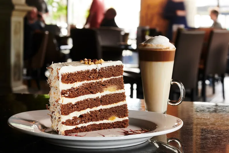 Oakville dessert restaurant serving Sky-High Carrot Cake with a specialty latte at Symposium Cafe