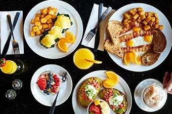 Symposium Cafe Restaurant all-day breakfast and weekend brunch featuring Eggs Benedict, French toast and fresh fruit.