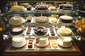 Symposium Cafe Restaurant gourmet dessert menu featuring specialty cakes, waffles, affogatos and ice cream treats.